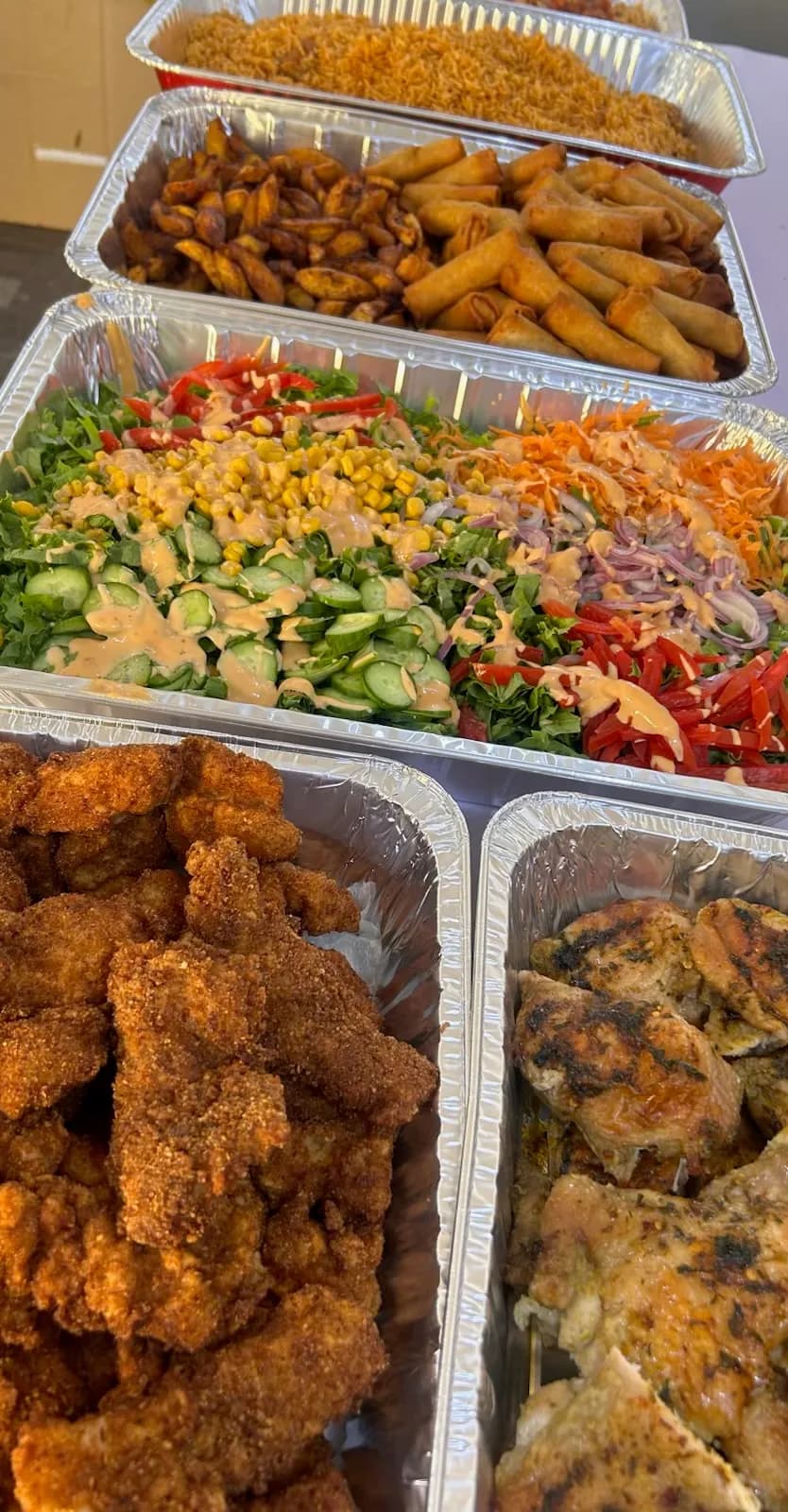 Rice, spring rolls and other dishes in sharing trays